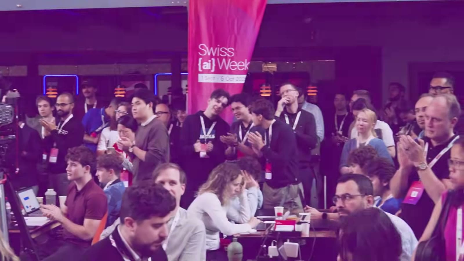 Crowd celebrating at the closing ceremony under the Swiss {ai} Weeks flag