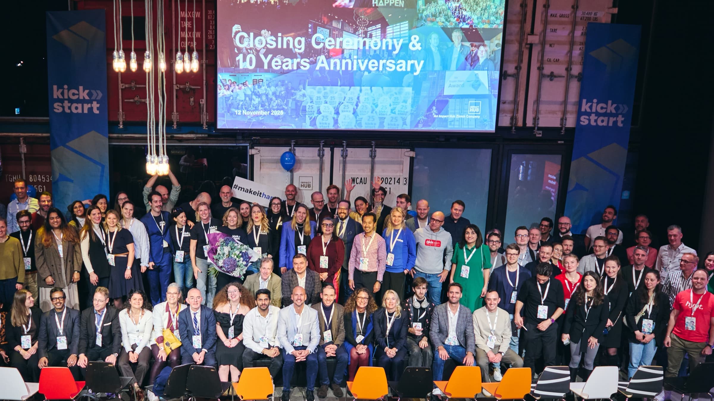 Large group photo of participants on stage at a closing ceremony