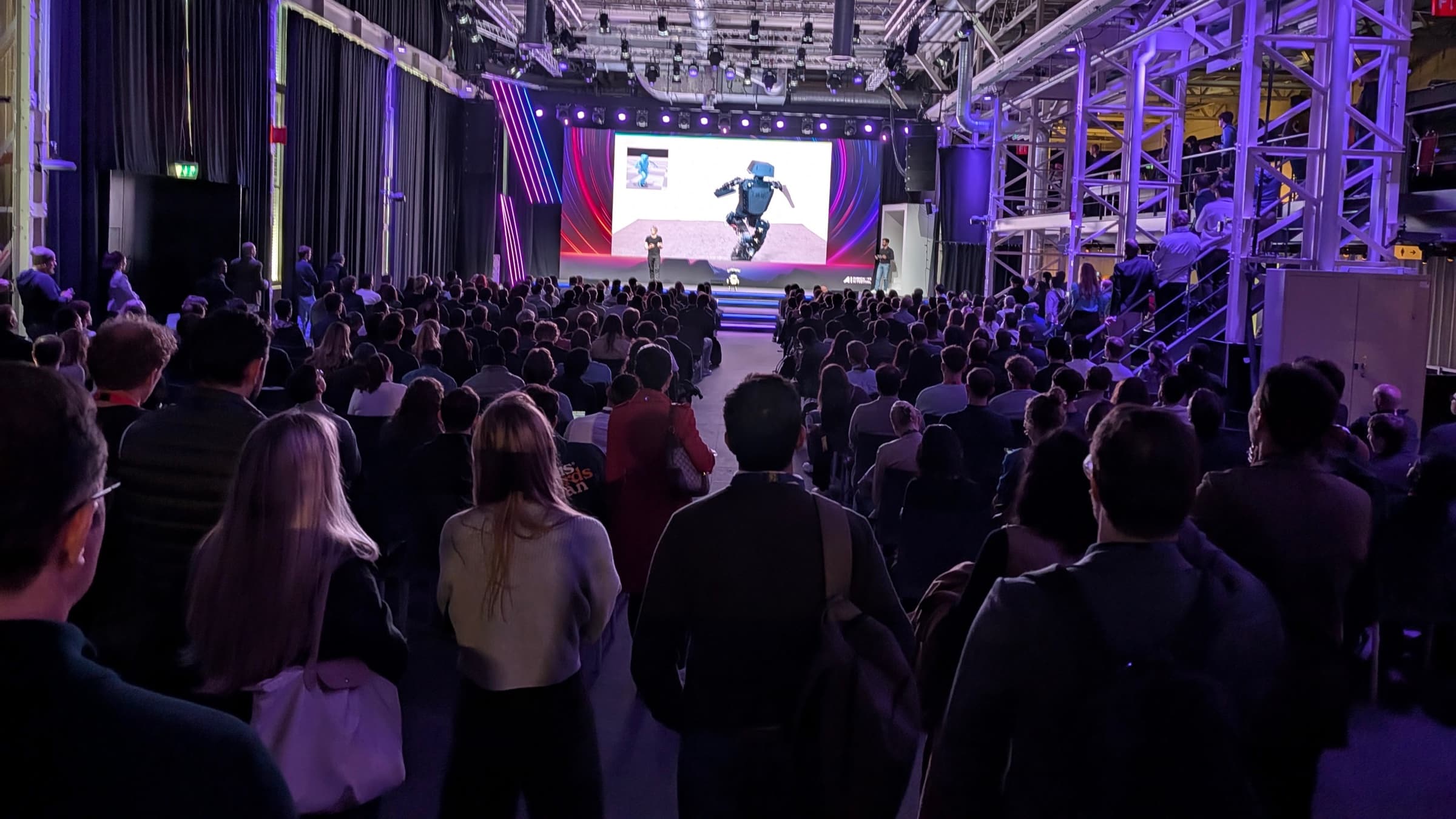 Packed hall watching a presentation on the main stage
